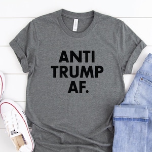May include: A gray t-shirt with the text "ANTI TRUMP AF." printed in black.