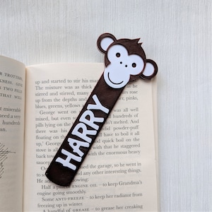May include: A brown monkey bookmark with a white face and the name "HARRY" printed in white letters.
