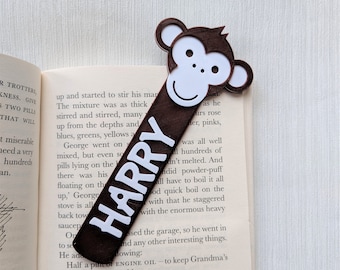 May include: A brown monkey bookmark with a white face and the name "HARRY" printed in white letters.