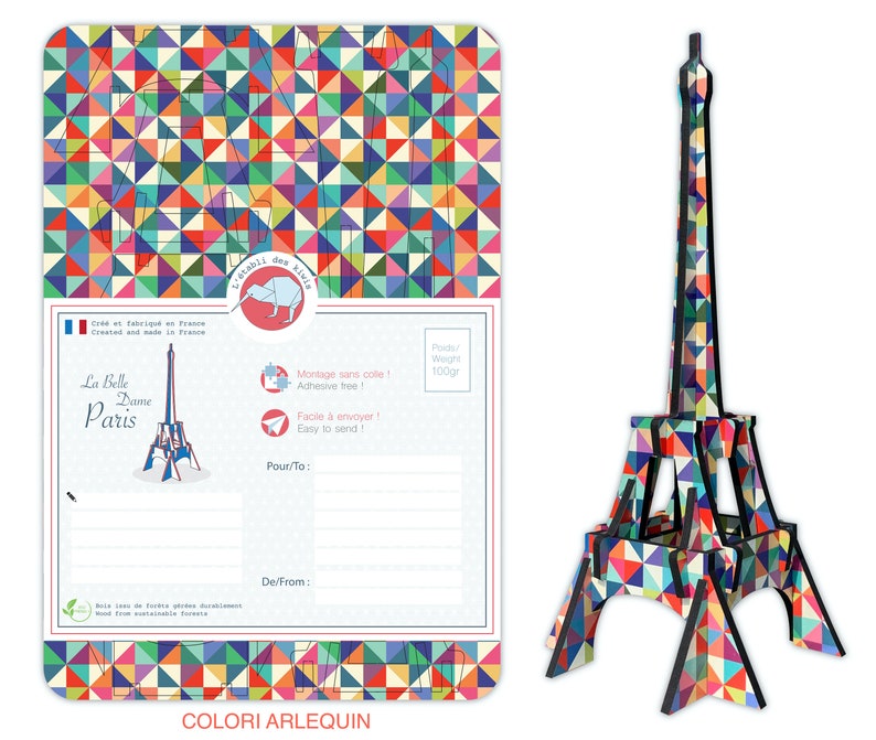 May include: A colorful, geometric Eiffel Tower model made of cardboard. The model is 100 grams and is easy to assemble. The packaging includes a postcard with a space to write a message and the text "La Belle Dame Paris".