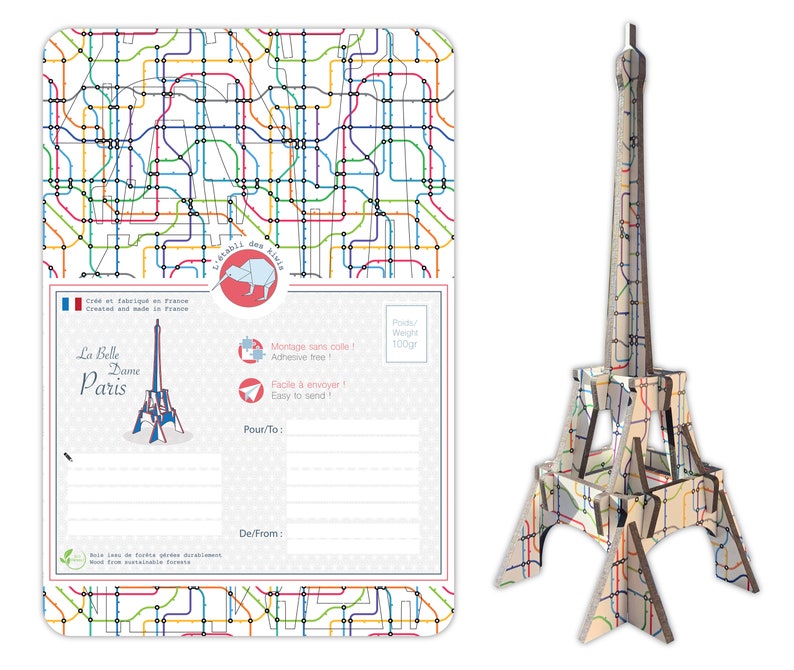 May include: A postcard featuring a colorful illustration of the Eiffel Tower with a Parisian metro map pattern. The postcard has a space for a message and the text "La Belle Dame Paris" on the front.