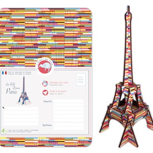 May include: A colorful, striped Eiffel Tower model postcard kit. The postcard features a space to write a message and includes the text "La Belle Dame Paris".