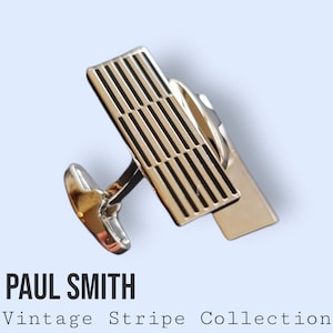 Könnte beinhalten: Silberne Manschettenknöpfe mit einem schwarz-weiß gestreiften Design. Die Manschettenknöpfe gehören zur Paul Smith Vintage Stripe Collection.
