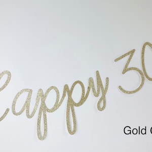 Pode incluir: Uma faixa dourada com glitter que diz "Happy 30th" em uma fonte cursiva. A faixa est&aacute; pendurada em uma fina corda branca sobre um fundo branco. As palavras "Gold Glitter" est&atilde;o abaixo.