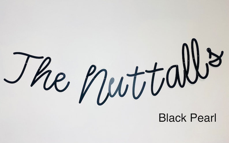 May include: Black script lettering on a white wall reads "The Nuttalls" with the text "Black Pearl" below.