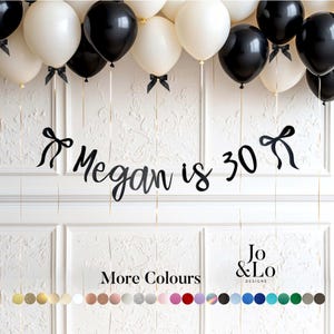 May include: A black and white balloon garland with black ribbon bows attached to the base of each balloon. A black script banner reads Megan is 30, flanked by two black bow icons. A colour palette chart displays various circular colour swatches.