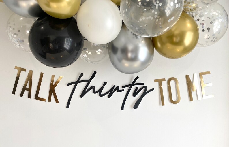May include: Gold, black, and silver balloons with confetti. A banner reads "TALK thirty TO ME" in gold and black letters.