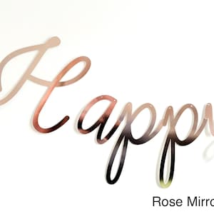 Pode incluir: Faixa "Happy" com acabamento espelhado rosa. A palavra "Happy" &eacute; escrita em uma fonte cursiva. A faixa &eacute; feita de um material reflexivo e foi projetada para ser pendurada. O texto "Rose Mirror" est&aacute; na parte inferior.