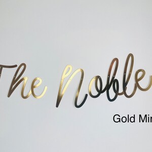 May include: Gold mirror banner with the text "The Nobles" in a cursive font.
