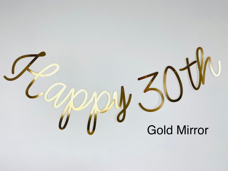Pode incluir: Bandeira dourada espelhada com a frase "Happy 30th" em fonte cursiva. Ideal para uma festa de anivers&aacute;rio. O texto "Gold Mirror" est&aacute; abaixo da bandeira.