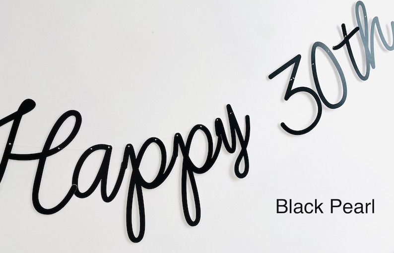 Pode incluir: Faixa de metal preta que diz "Happy 30th" em uma fonte cursiva. O texto "Black Pearl" est&aacute; abaixo. Montado em uma parede branca.