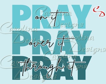 May include: A light blue graphic design with the word "PRAY" repeated three times. The phrases "on it", "over it", and "through it" are written in a cursive font. The text "Carolina Designs" is also present.