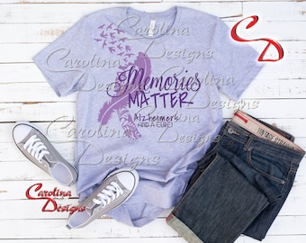 May include: A heather gray t-shirt with a purple feather design and the text "Memories Matter - Alzheimer's Find A Cure!" printed on the front.