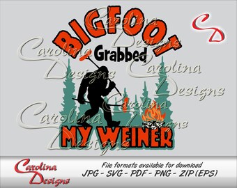 May include: A graphic design featuring the text "Bigfoot Grabbed My Weiner" in orange and black. A silhouette of Bigfoot is walking through a forest with a campfire in the background. The design includes the Carolina Designs logo.