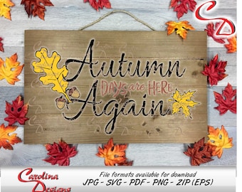 May include: A wooden sign with the text "Autumn Days are Here Again" in black distressed lettering. The sign is decorated with two yellow leaves and acorns. The sign is surrounded by fall leaves in various shades of red, orange, and yellow.