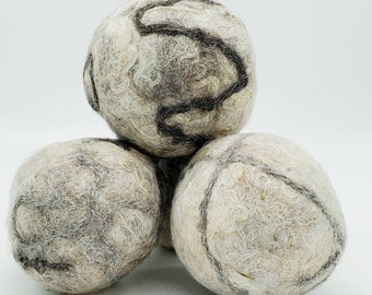 May include: Three gray and white wool dryer balls with black swirl designs.