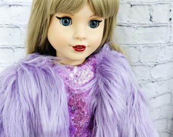 May include: A doll with blonde hair wearing a purple faux fur jacket over a pink sequined dress. The doll has blue eyes and red lipstick.