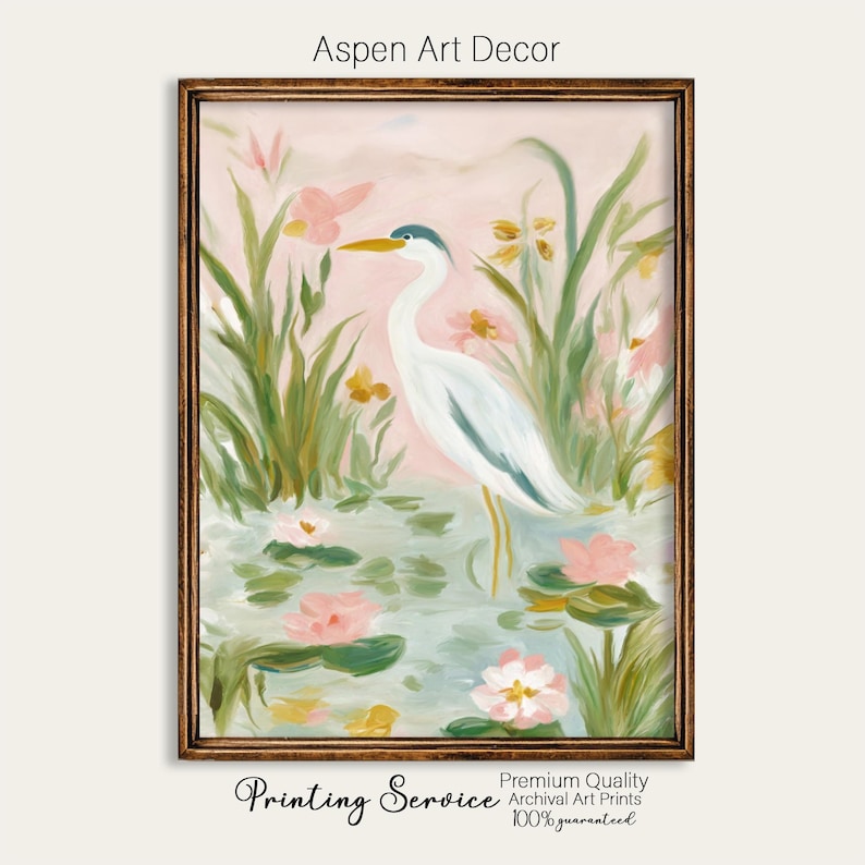 May include: A framed art print featuring a white heron standing in a pond with pink water lilies and green reeds. The artwork has a soft, pastel color palette with the text "Aspen Art Decor" at the top.