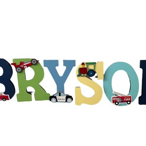 Puede incluir: Letrero de nombre de madera que deletrea "BRYSON" en varios colores. Cada letra est&aacute; decorada con un veh&iacute;culo diferente, incluyendo un coche de carreras, un coche de polic&iacute;a, un tren, un cami&oacute;n de bomberos y un monster truck. Ideal para la habitaci&oacute;n de un ni&ntilde;o.