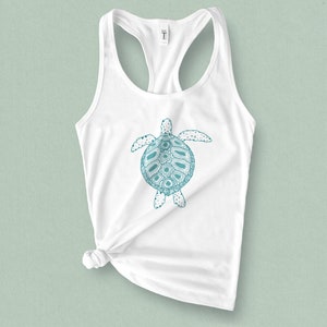 May include: White tank top with a teal blue graphic of a turtle with a detailed shell design.