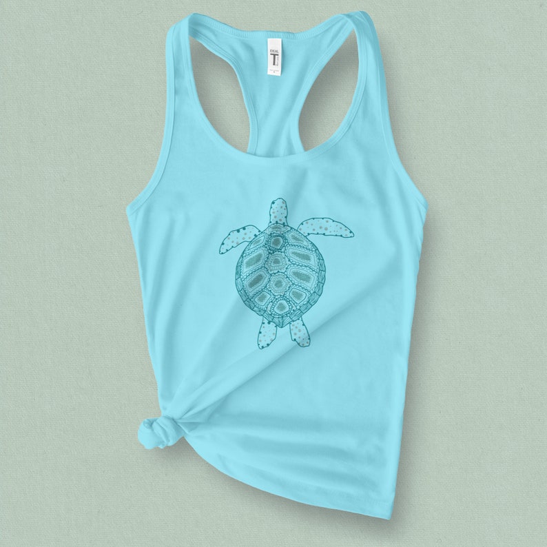 May include: A light blue tank top with a teal sea turtle graphic. The turtle has a detailed design with a patterned shell.