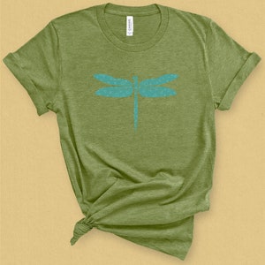 May include: A green t-shirt with a blue dragonfly design. The dragonfly is made up of small circles.