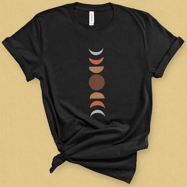 May include: Black t-shirt with a graphic of a moon phases design in shades of gray, red, orange, and brown.