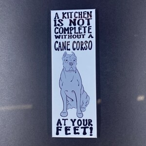 May include: A white sticker with black text that reads "A kitchen is not complete without a Cane Corso at your feet!"  A cartoon image of a Cane Corso dog is sitting in the centre of the sticker.