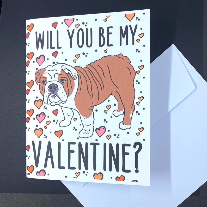 May include: A Valentine's Day card featuring a cartoon bulldog with the text "Will you be my Valentine?" surrounded by pink and orange hearts.