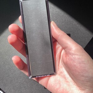 May include: A rectangular magnet with a black background and white text that reads "MADE IN THE USA" on the back.