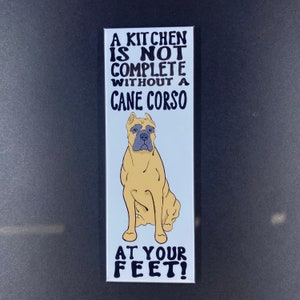May include: A white magnet with black text that reads "A kitchen is not complete without a Cane Corso at your feet!" and a cartoon image of a tan Cane Corso dog sitting.
