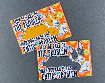 May include: Two rectangular magnets with a cartoon corgi illustration. One magnet features an orange corgi, the other a gray corgi. Both magnets have the text "WHY BE PART OF THE PROBLEM WHEN YOU CAN BE THE ENTIRE PROBLEM."