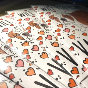 May include: A stack of Valentine's Day cards featuring a cartoon bulldog with hearts and the text "Will you be my Valentine?"