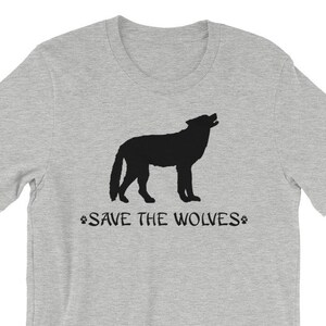 Może przedstawiać: Szary T-shirt z czarną sylwetką wyjącego wilka i nadrukiem "SAVE THE WOLVES" z przodu.
