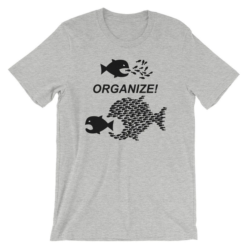 May include: A gray t-shirt with a black graphic of two fish. The top fish is eating smaller fish, and the bottom fish is made up of smaller fish. The text "ORGANIZE!" is printed on the shirt.