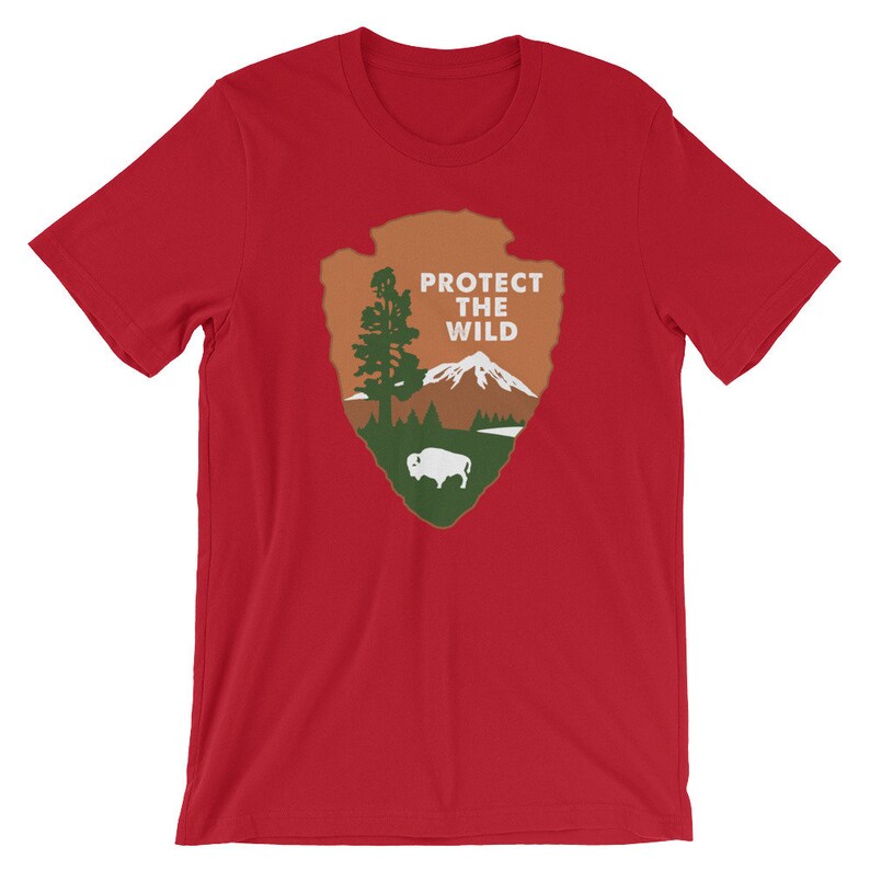 May include: Red t-shirt with a green, brown, and white graphic of a national park arrowhead with the text "PROTECT THE WILD".