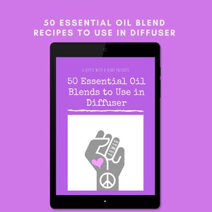 May include: A black tablet shows a purple screen with the text "50 Essential Oil Blends to Use in Diffuser." The screen also features a gray fist with a pink heart and peace sign. The tablet is set against a purple background.