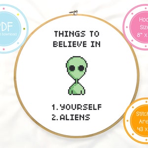 May include: Cross stitch pattern for an 8 inch hoop featuring a green alien with the text "Things to Believe In" and "1. Yourself 2. Aliens".