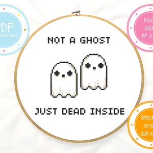 May include: A cross-stitch pattern featuring two white ghosts with black eyes and the text "Not a ghost, just dead inside". The pattern is designed for an 8-inch embroidery hoop and has a stitched area of 69 x 60 stitches.