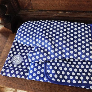 May include: A blue oven mitt and matching pot holder featuring a white polka dot pattern. The fabric items have a circular white label with the text Manufaktura Boleslawiec and a stylized jar icon printed on the corner of the pot holder.
