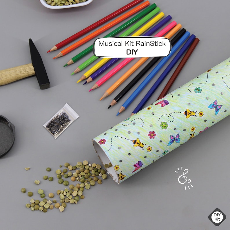 K&ouml;nnte beinhalten: Ein DIY-Musikkit zum Basteln eines Regensticks. Das Kit enth&auml;lt eine Pappr&ouml;hre, farbige Bleistifte, eine T&uuml;te mit Erbsen, einen Hammer und N&auml;gel. Die R&ouml;hre ist mit einem Bienen- und Schmetterlingsmuster verziert. Der Text auf dem Bild lautet "Musical Kit RainStick DIY".