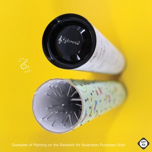 K&ouml;nnte beinhalten: Zwei Beispiele f&uuml;r einen Regenstick, einer mit einem schwarz-wei&szlig;en Musiknoten-Design und der andere mit einem bunten Muster. Der Regenstick ist ein hohler Schlauch mit Metallstiften im Inneren, die beim Umdrehen einen regnerischen Klang erzeugen.