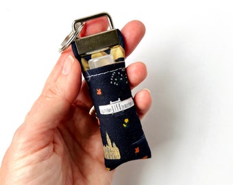 Portachiavi con balsamo per labbra / Rifle Paper Co. Bon Voyage World Traveler in tessuto blu navy