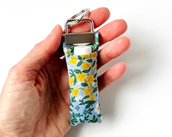 Portachiavi con balsamo per labbra / Rifle Paper Co. Wildwood Garden, tessuto floreale blu e giallo