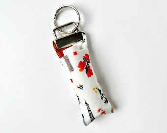 Portachiavi con balsamo per labbra / Rifle Paper Co. Bon Voyage World Traveler in tessuto bianco