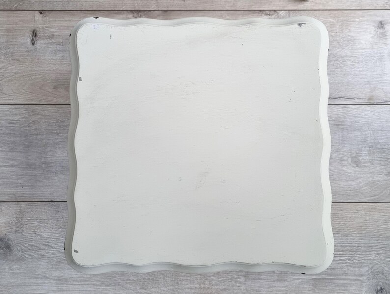 May include: White painted wooden tray with a scalloped edge. The tray is made of wood and has a distressed white paint finish.