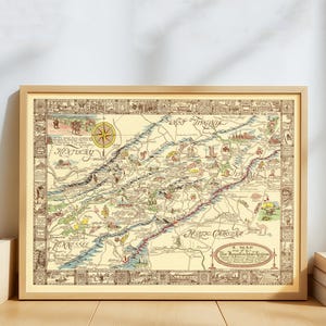 Könnte beinhalten: Eine gerahmte Vintage-Karte der Appalachen-Region mit detaillierten Illustrationen und Text. Die Karte befindet sich in einem Holzrahmen und hat einen cremefarbenen Hintergrund mit braunen und roten Akzenten. Eine Windrose befindet sich oben in der Mitte.