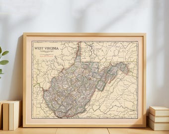 May include: A framed vintage map of West Virginia, featuring detailed cartography in muted tones of beige, brown, and green. The map is enclosed in a light wooden frame, showcasing the state's geographical features and place names.