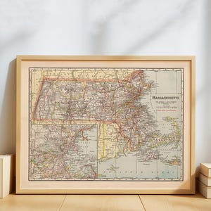Può includere: Mappa vintage incorniciata del Massachusetts, con dettagliate indicazioni stradali e cittadine. La mappa è in una cornice di legno chiaro, con il nome dello stato ben visibile. I colori della mappa includono beige, rosso e verde.