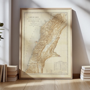 Può includere: Mappa vintage incorniciata del Libano, con dettagli geografici e testo in francese. La mappa è nei toni del beige e del marrone, con una cornice in legno. Il titolo "CARTE DU LIBAN" è visibile in alto.